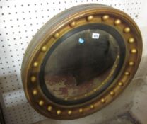 A giltwood convex wall mirror in Regency style, convex mirror plate, reeded ebonised moulding, ball