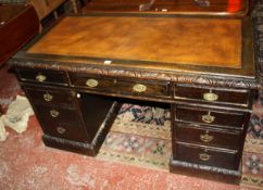 A Victorian oak pedestal desk with nine drawers 137cm wide