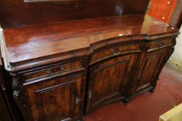 A 19th Century German mahogany inverted breakfront sideboard with a shaped back and three drawers