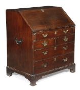 A George III hardwood bureau, circa 1790, the fall opening to an arrangement of drawers and pigeon