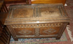 A 17th Century carved oak coffer with a double panel top and front raised on stile feet 96cm wide