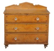 A Victorian grained pine chest of drawers, circa 1880, painted to simulate oak, the shaped back