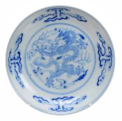 A Chinese blue and white saucer dish decorated with a five-clawed dragon chasing a flaming pearl