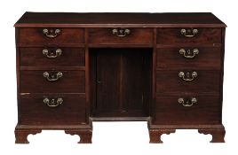 A George III mahogany kneehole desk circa 1780 with a rectangular top and...  A George III