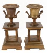 A pair of gilt metal twin handled Campana urns on stands, late 19th century  A pair of gilt metal