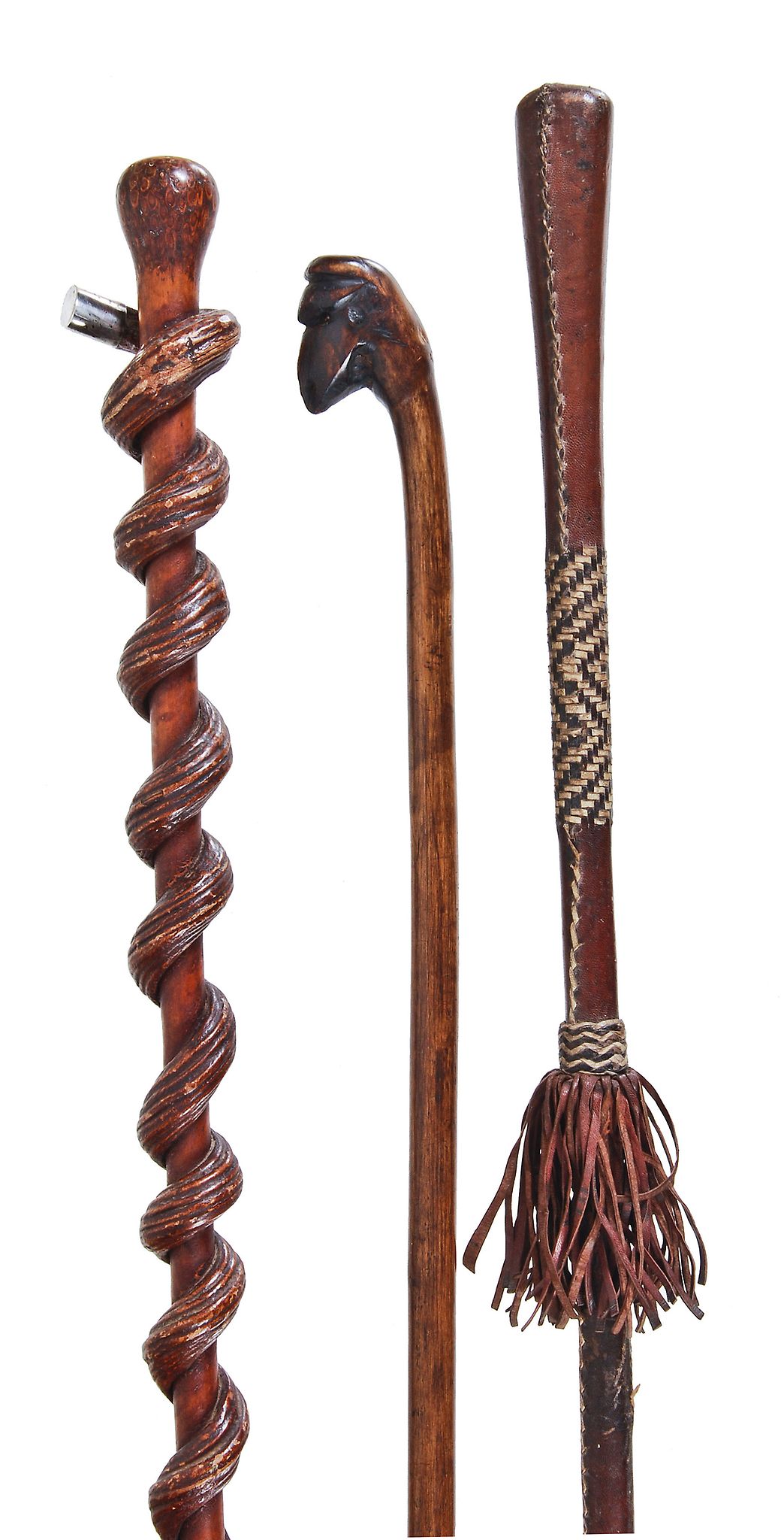 A carved and stained wood and white metal mounted walking stick  A carved and stained wood and white