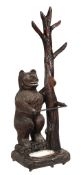 A Black Forest style carved wood stick stand, late 19th/ early 20th century  A Black Forest style