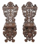 A pair of Italian carved walnut hall chairs in Renaissance style second half...  A pair of Italian