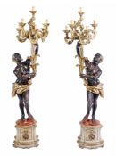 A pair of Continental carved giltwood Blackamoor torcheres  A pair of Continental carved giltwood