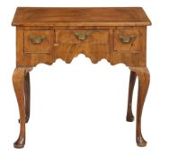 A George II walnut side table circa 1740 with a rectangular top with...  A George II walnut side