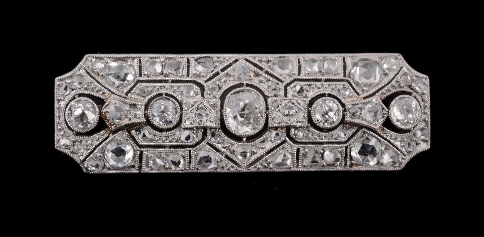 A diamond bar brooch, circa 1925, the rectangular shaped pierce panel set...  A diamond bar brooch,