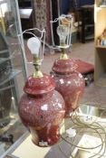 A pair of mottled red table lamps with faux lizard skin shades (sold as parts). There is no