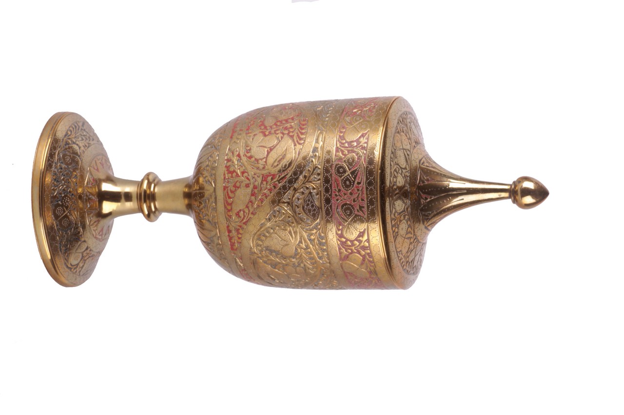An Indian brass goblet and cover, with floral decoration chased with red enamel, 19cm high. There is