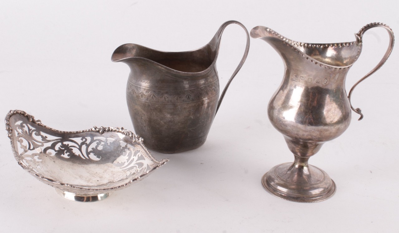 Two George III silver cream jugs, one ogee baluster pedestal by Charles Hougham, London 1787, the