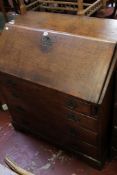 An early 19th century oak bureau with a fitted interior over drawers to the base. There is no