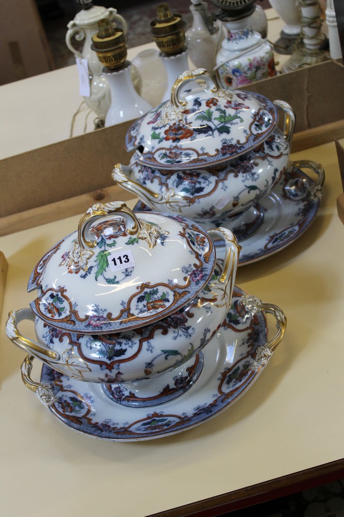 A pair of English ironstone soup tureens, covers and stands, printed in black and painted in