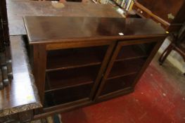A mahogany bookcase with a pair of glazed doors enclosing shelves, early 20th century, 92cm high,