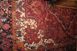 A Middle Eastern rug with red ground and central lozenge medallion 330 x 245cm