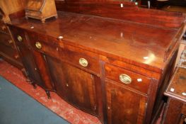 A George III style mahogany sideboard with rear gallery, above three drawers and cupboards on reeded