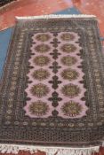 A Caucasian rug with twelve central medallions mauve guard, 180 x 120cm approximately (Purchased