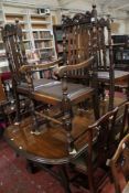 A reproduction oak dining table and five slatted high back dining chairs. There is no condition