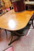 A Regency style mahogany twin pedestal dining table with a single extension leaf. There is no