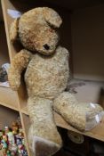 A plush early 20th century teddy bear; approximately 80cm long. There is no condition report