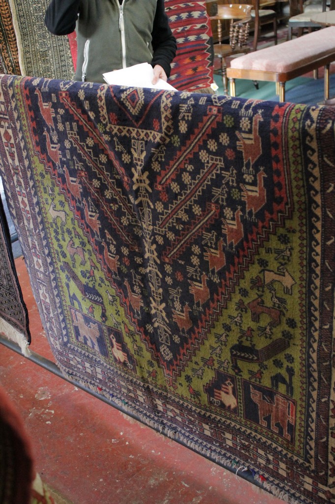 A blue ground rug with stylized decoration and animals 212 x 117cm. There is no condition report - Image 2 of 2