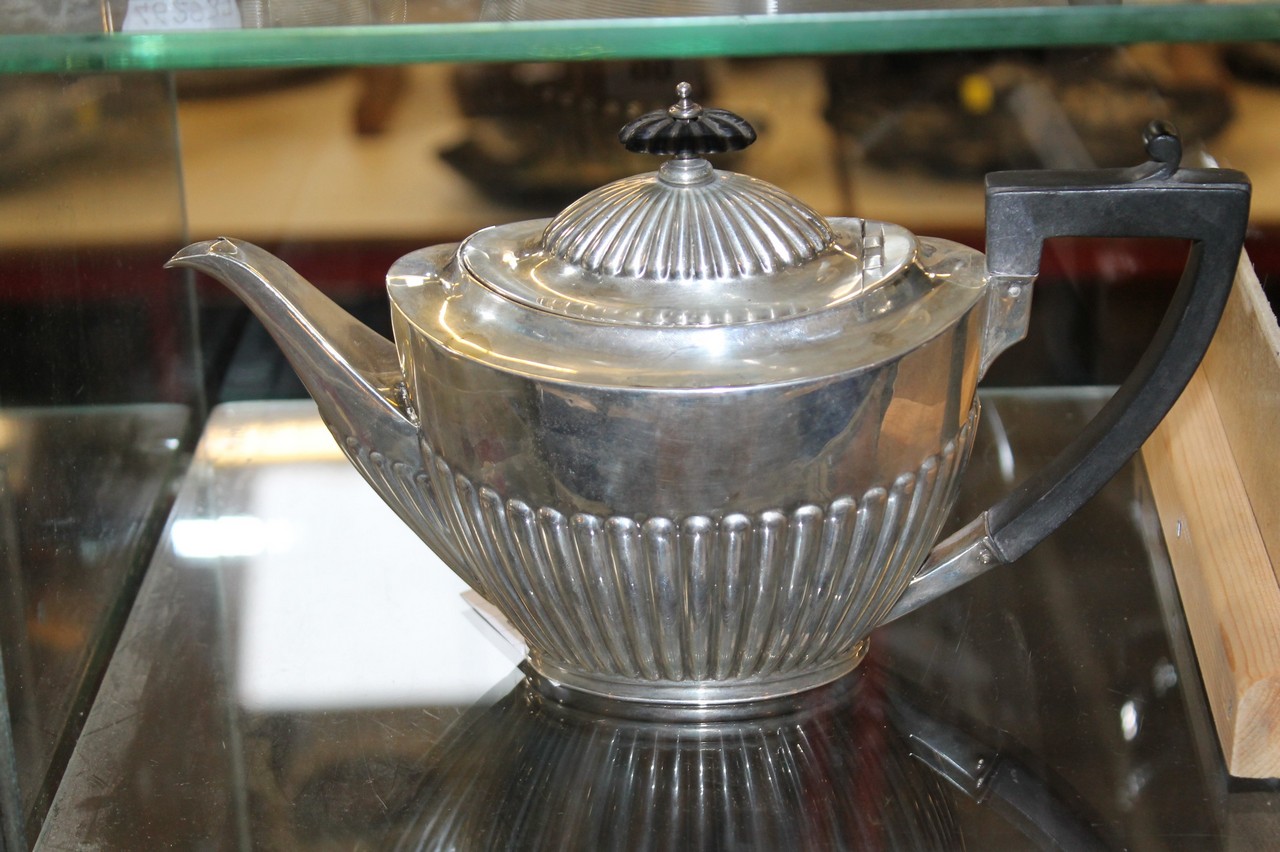 An Edwardian silver oval tea pot by Goldsmiths and Silversmiths Co. Ltd., London 1904, with a