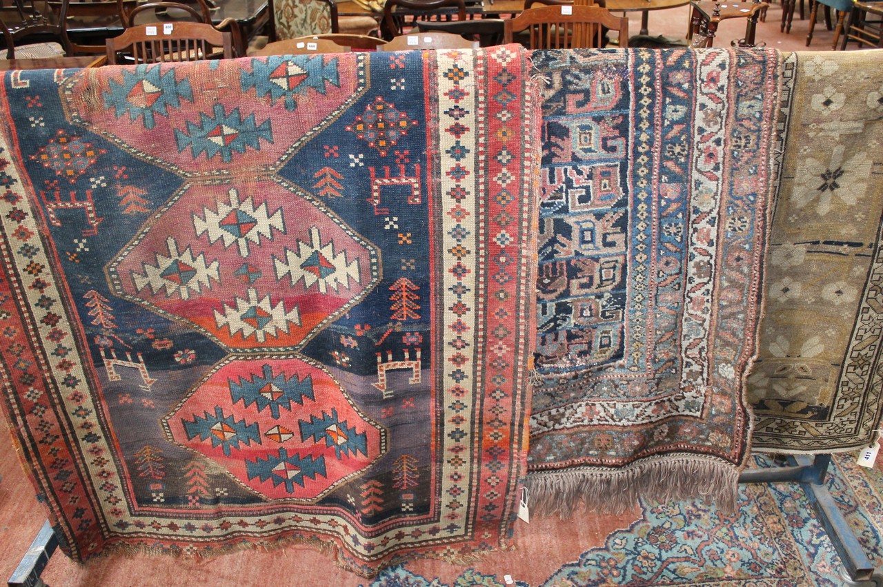 A Caucasian rug 220 x 114cm together with two further rugs (a/f). There is no condition report