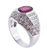 A ruby and diamond bombe ring, the central oval cut ruby in a collet setting  A ruby and diamond