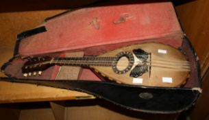 A mandolin, recently re-strung, with butterfly detail and case. There is no condition report