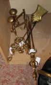 A set of three brass firetools, two further tools a pair of lion mask andirons and a small trivet
