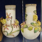 A pair of pottery vases with applied floral decoration 27cm high. There is no condition report