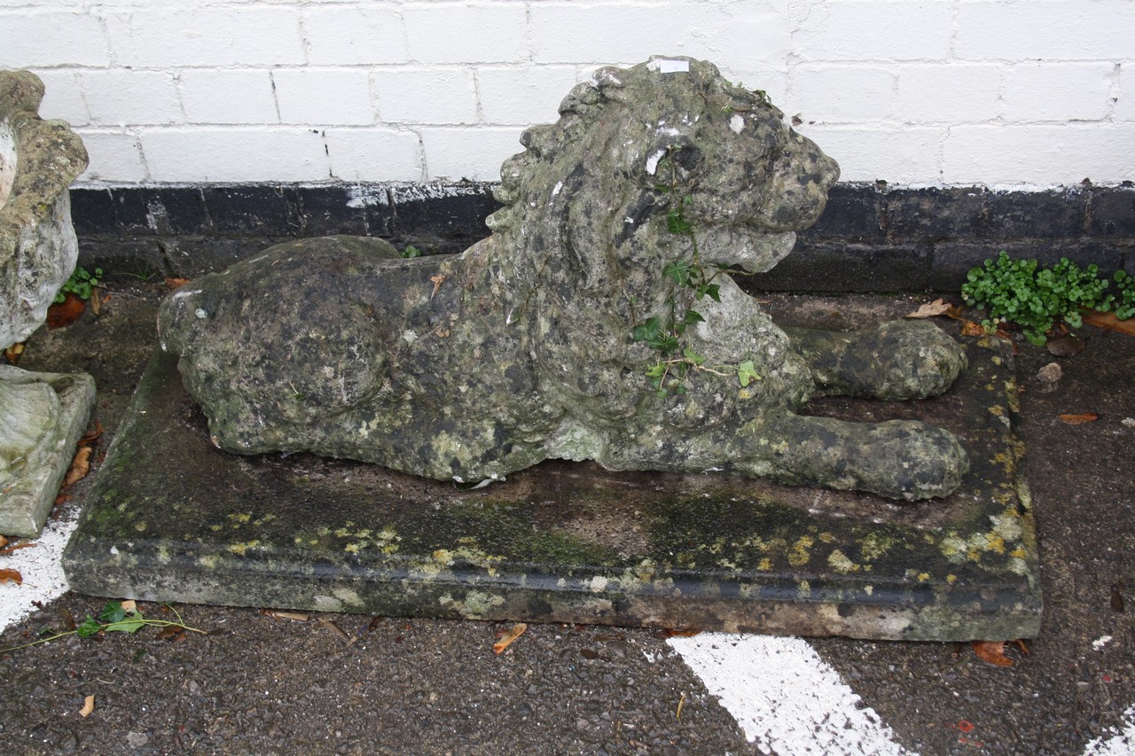 A reconstituted stone model of a lion recumbent There is no condition report available on this lot.