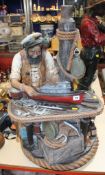 A resin figure of an old "sea salt" with a parrot on his shoulder making a model boat, 84cm high