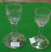 Two various facet-stemmed wine glasses, each with an ovoid bowl, one cut and polished with an `