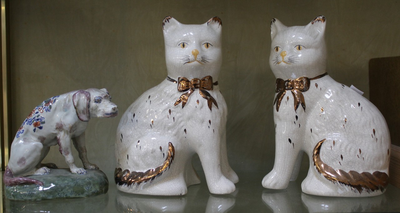 A Delft dog marked AK to the base 12cm high and a pair of white crackle glazed cats. There is no