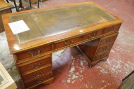 A reproduction yew pedestal desk with nine drawers 137cm wide