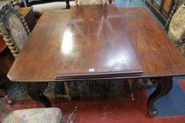An early 20th Century mahogany extending table with two additional leaves on carved cabriole legs