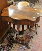 A Victorian mahogany work table with a shaped top above a work basket on moulded base and scrolled