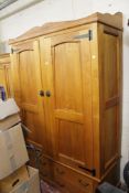 A teak wardrobe of recent manufacture with a shaped gallery to the cornice above twin arched