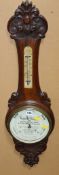 A Victorian carved walnut aneroid wheel barometer, the 7.5inch circular cream painted register