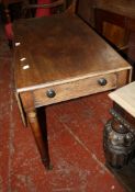 An early 19th century mahogany Pembroke table with rounded drop-flaps, frieze drawer, turned