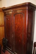 A Victorian mahogany cupboard with a pair of arch moulded doors enclosing linen slides and drawers