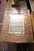 A beaten copper framed mirror 67 x 51cm and a Victorian mahogany dressing mirror. There is no