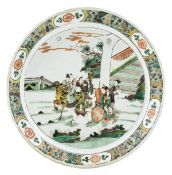 A famille verte charger, Kangxi period, depicted painted with a fenced garden scene featuring a man