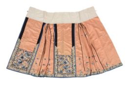 A coral ground pleated skirt for a Han woman, circa 1900, finely embroidered in satin stitch and