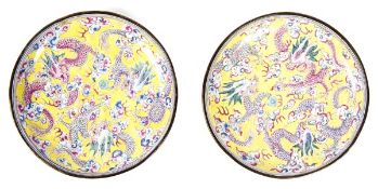 A pair of painted enamel dishes, Qianlong period, of shallow, rounded form, painted in famille rose