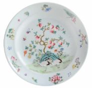 A famille rose dish of circular form with broad rim, decorated in overglaze famille rose enamels